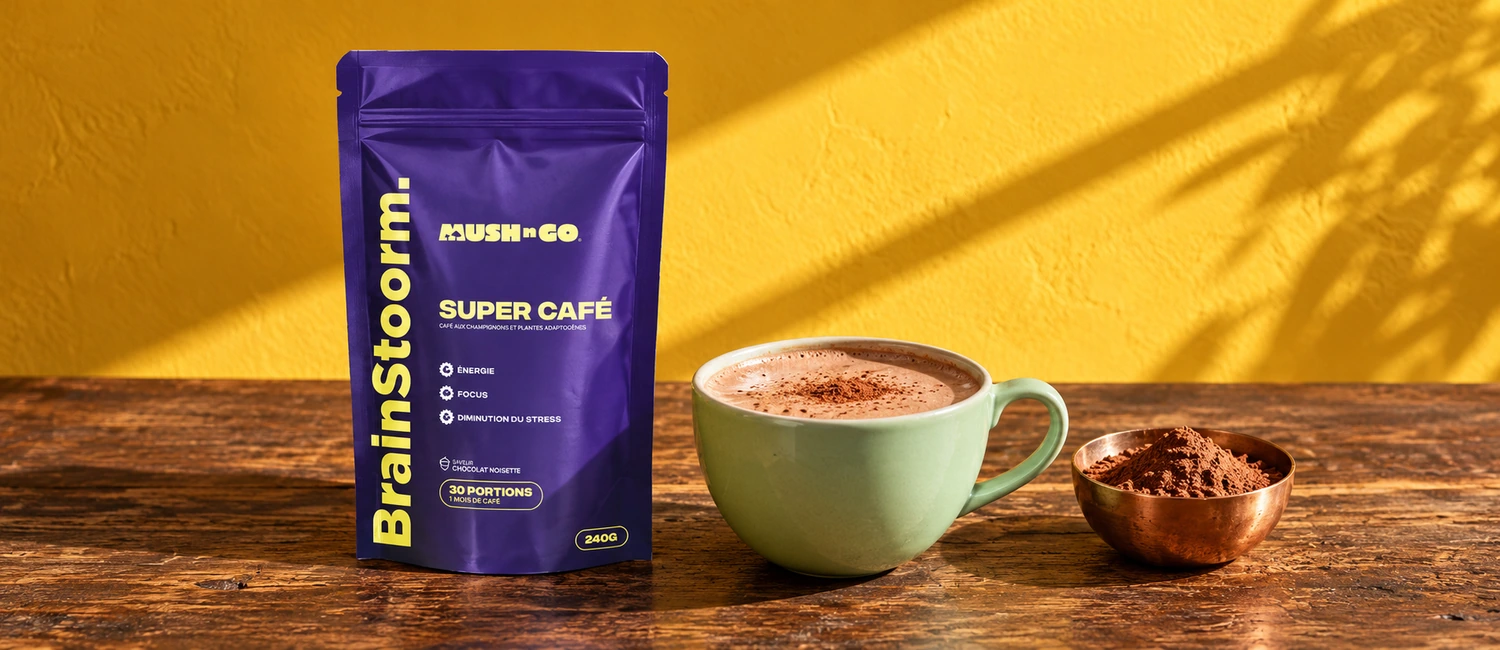 Paquete de Brainstoorm Choco de Mush N Go junto a una taza de bebida de cacao y un cuenco de cacao en polvo sobre una mesa de madera
